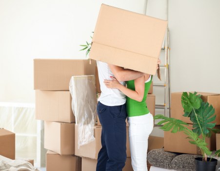 A mover unpacking household items into a new Swiss Cottage flat