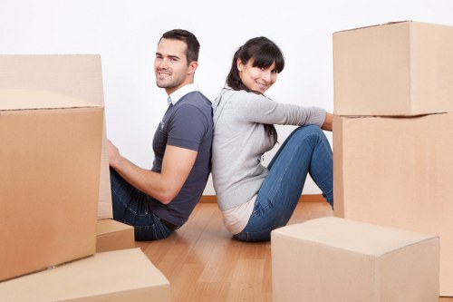 Movers handling boxes and furniture in a Swiss Cottage property