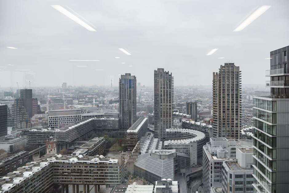 A view of the O2 Centre in Swiss Cottage with its distinctive white exterior and docking spires, visible against a cloudy sky during late afternoon or early evening. The image shows the lower part of